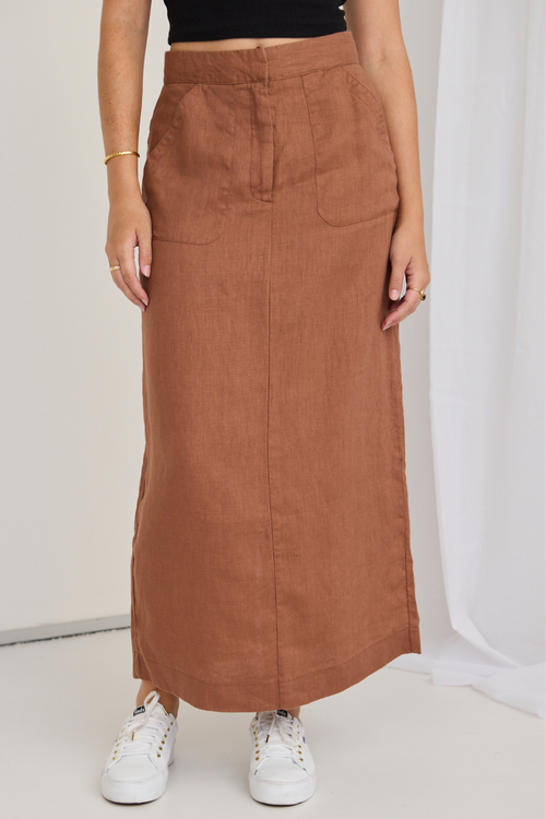 model wears a black tank top and a mocha brown midi skirt with white sneakers