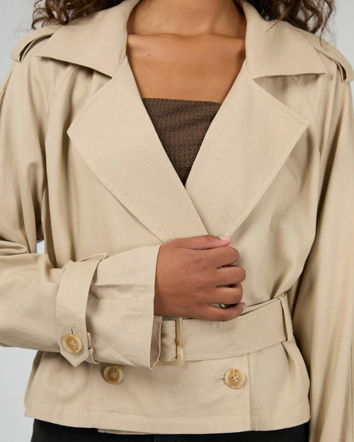 model wears taupe trench coat