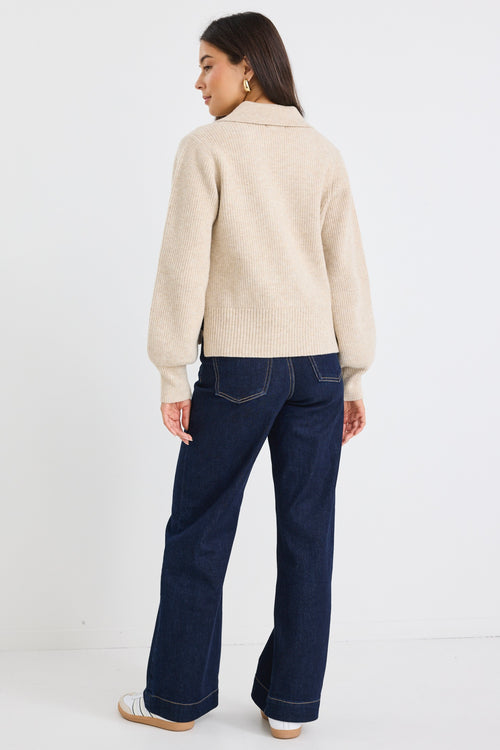 Model wears a beige knit collared jumper