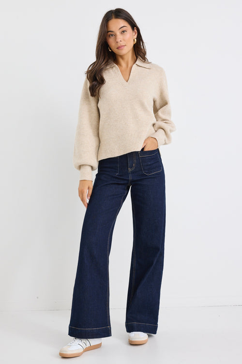 Model wears a beige knit collared jumper