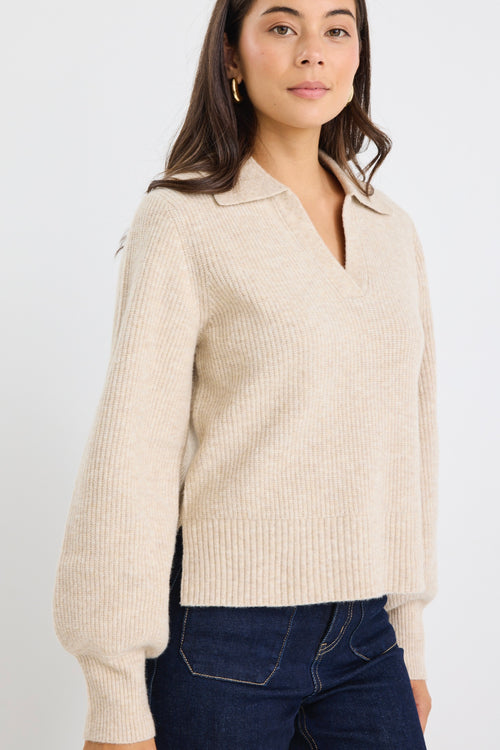 Model wears a beige knit collared jumper