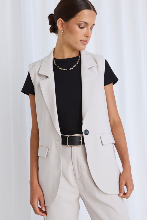 model wears a beige vest with beige pants