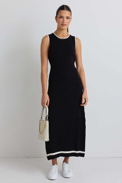 model wears black rib knit maxi dress and white sneakers