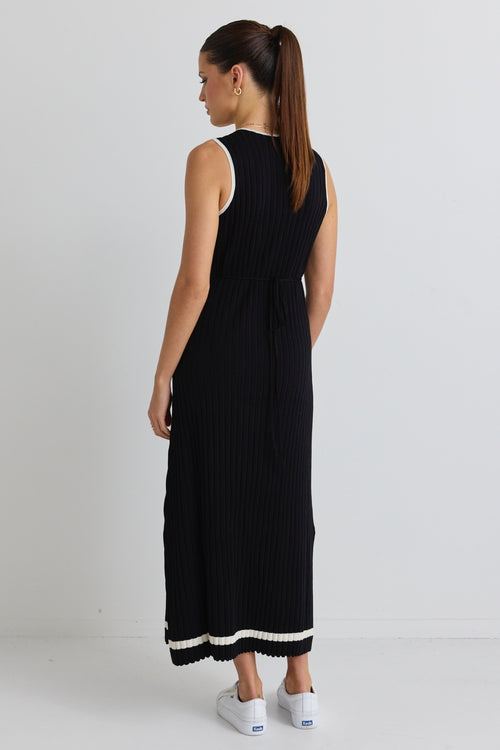 model wears black rib knit maxi dress and white sneakers