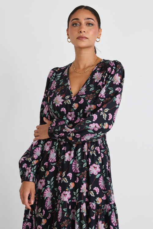 model wears a black floral maxi dress