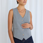 model wears a grey vest with jeans