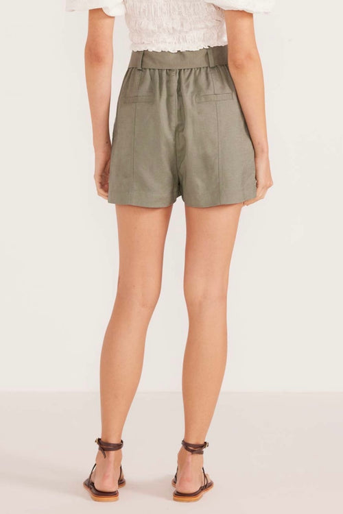 model wears green linen shorts