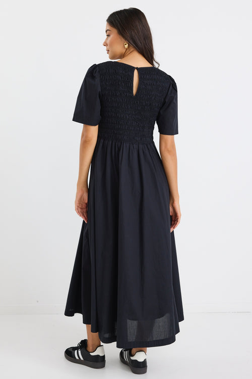 model wears a black linen maxi dress