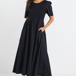 model wears a black linen maxi dress