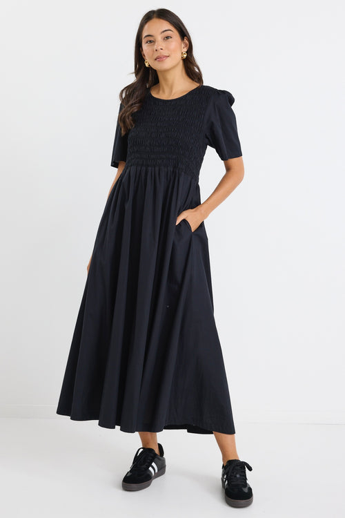 model wears a black linen maxi dress