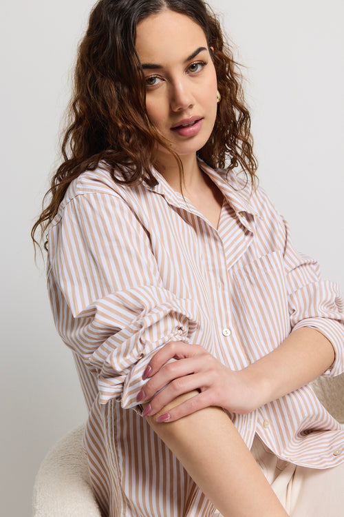 Model wears a stripe white and tan shirt 