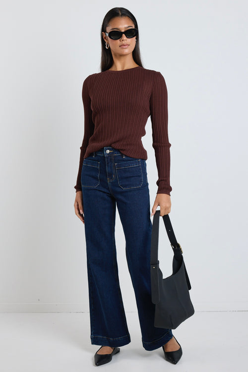 Model wears a brown long sleeve rounded neck ribbed top