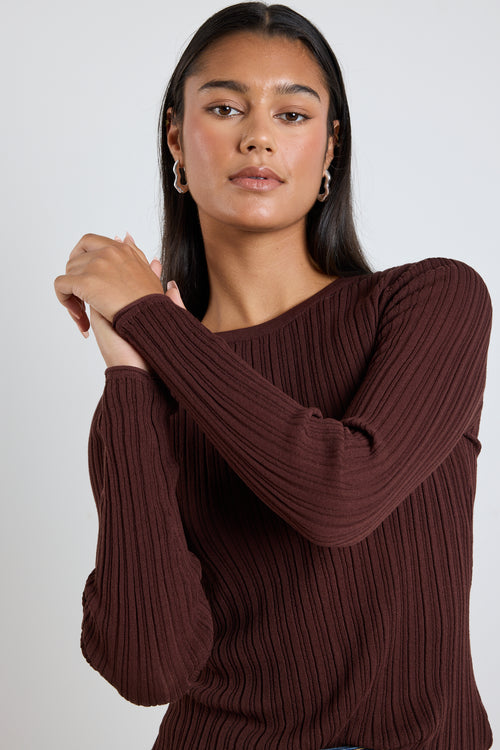 Model wears a brown long sleeve rounded neck ribbed top