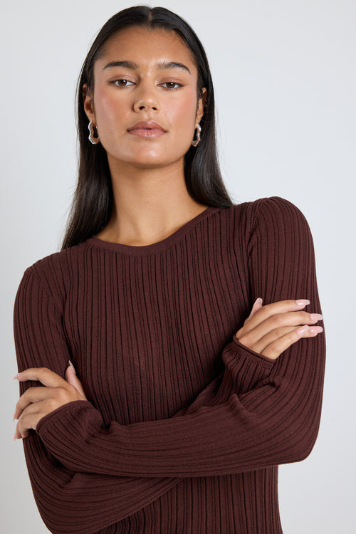 Model wears a brown long sleeve rounded neck ribbed top