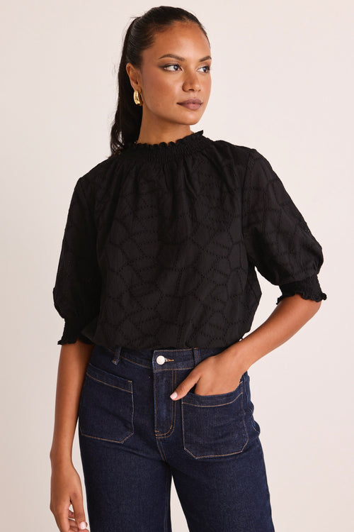 model wears a black blouse 