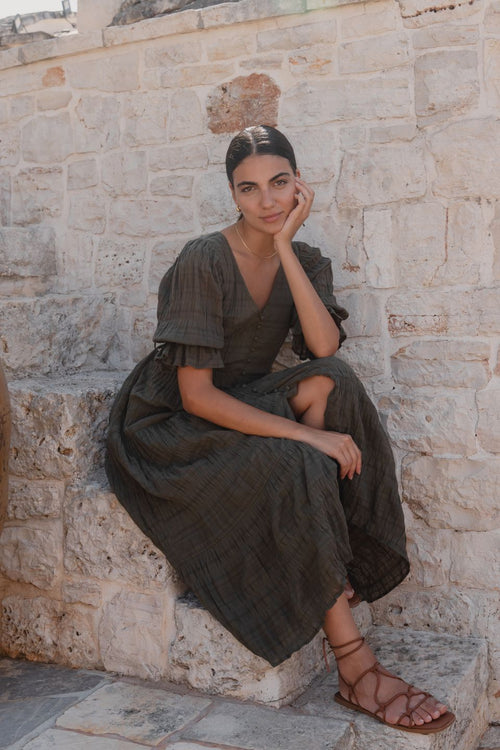 model wears a green midi dress