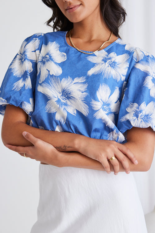 model in blue floral crop top and white skirt