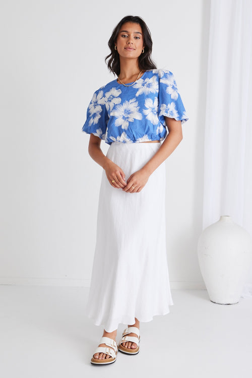 model in blue floral crop top and white skirt