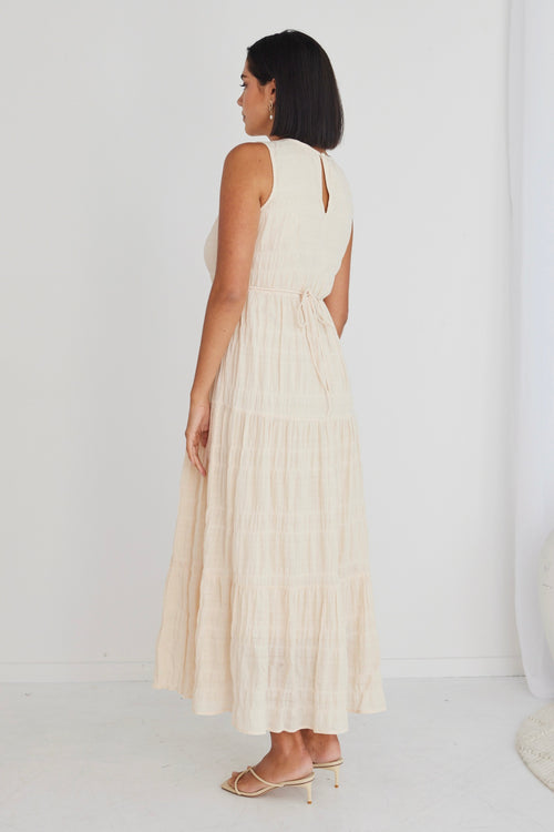 model in long sand coloured dress and matching heels