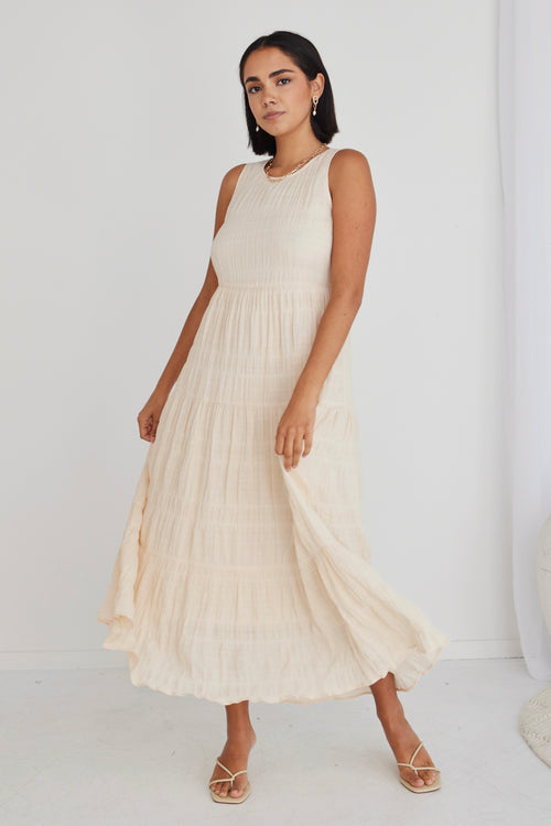 model in long sand coloured dress and matching heels