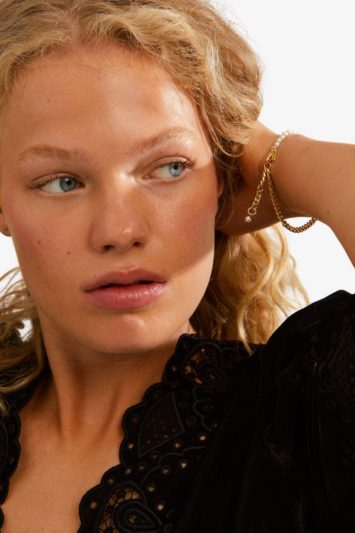 model wearing gold and pearl bracelet