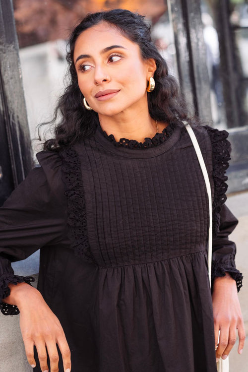 model wearing black long sleeve mini dress