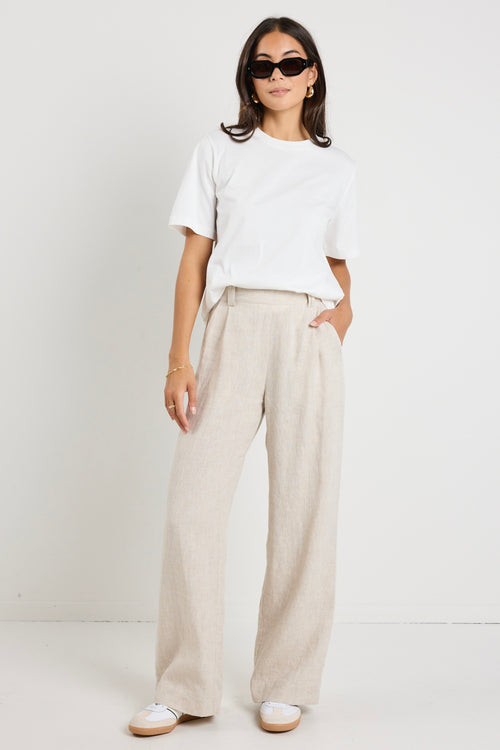 model wears natural linen pants with white top