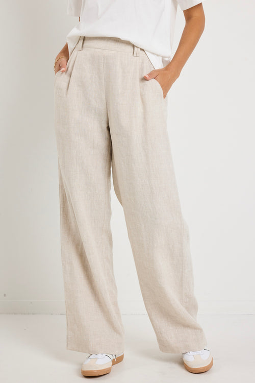 model wears natural linen pants with white top