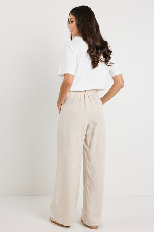 model wears natural linen pants with white top