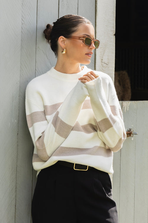 model wears a stripe knit with black pants