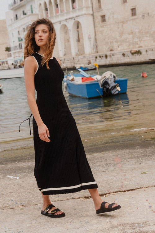 model wears black rib knit maxi dress outside by the water