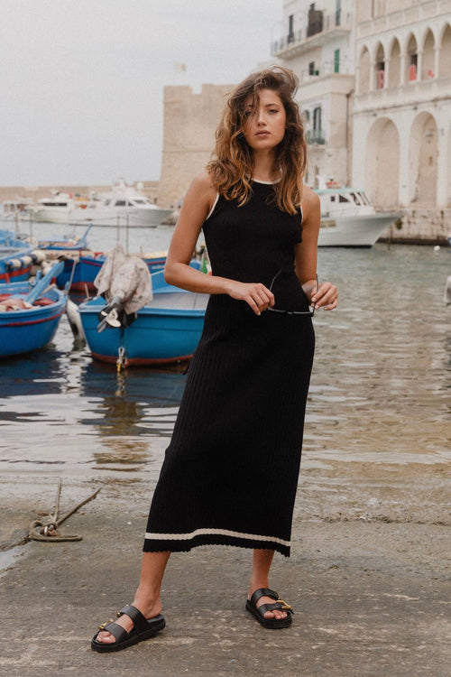 model wears black rib knit maxi dress outside by the water