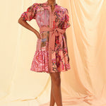 the model is wearing a pink floral mini dress