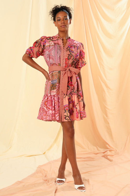 the model is wearing a pink floral mini dress